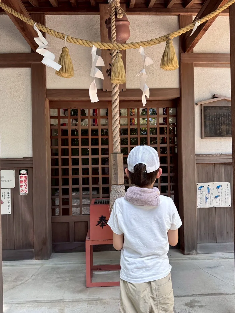 神社の前に立つ子ども